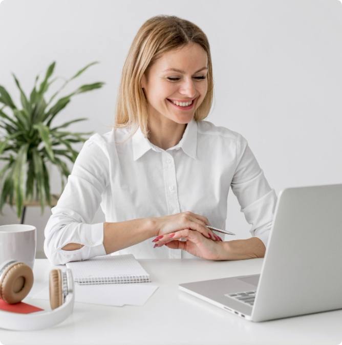 A smiling girl having laptop in front of her